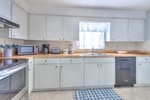 Fully equipped kitchen with modern appliances and basic cooking equipment
