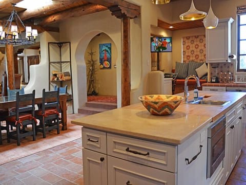 In the open plan designer kitchen, a television swings easily between the kitchen and a cozy window seat alcove with computer desk.