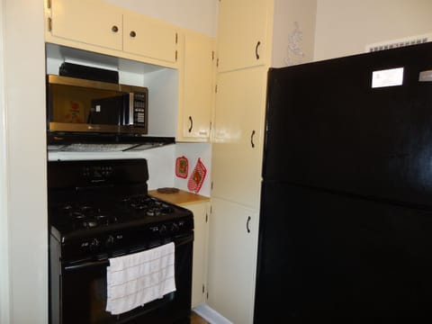 Kitchen with full refrigerator and stove