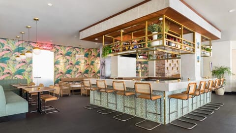Sip cocktails at the chic, sunlit bar with lush décor.