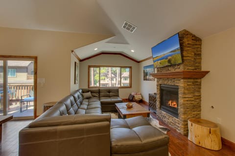 - Cozy living area with stone fireplace warmth  
- Mounted smart TV for streaming and movie nights  
- Large sectional seating for group relaxation