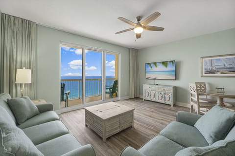 Living room with direct Gulf views, 65" Smart TV, and balcony access. The beach is right outside that door.