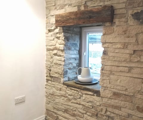 Original stone walls line the staircase and landing of Weaver's holiday cottage