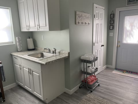 View from bed side of room looking at kitchenette, bathroom door and front door