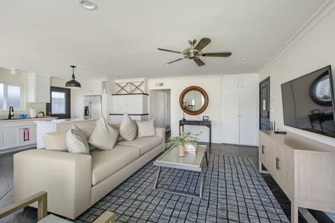 Large open concept living space with a kitchen island, dining area, a fireplace, and a smart TV with basic cable for a cozy family feel.