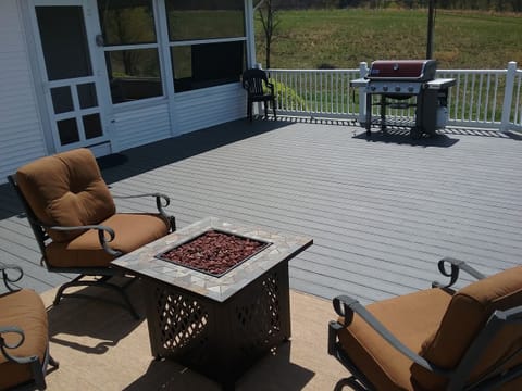 Expansive deck with large Weber grill, fire pit and chairs.