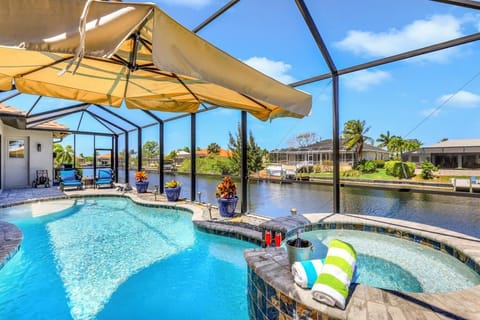 A view of the expansive pool deck with hot tub and views over the Gulf Access canal