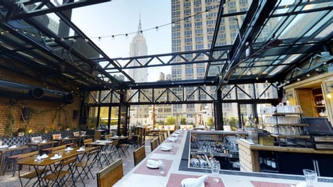 Dine under glass ceilings with sweeping skyline views above.