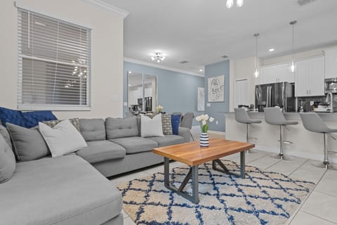 Unwind on your plush sectional sofa in this bright, open living space where comfort meets modern elegance and fresh flowers welcome you home.