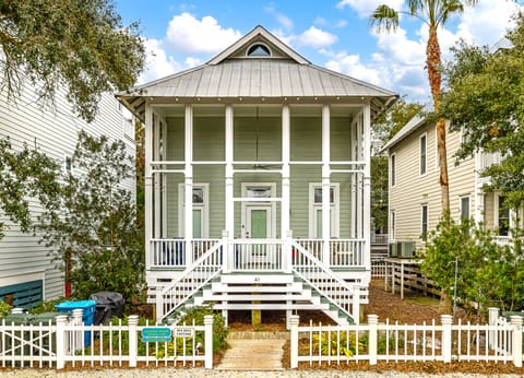 Coast Cottages East Beach Exterior - Elevated Coast Cottages home on East Beach, a two-minute walk to the ocean with front porch, white picket fence, and covered parking.