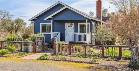 Charming blue cottage with a welcoming front porch, garden views, and cozy character - perfect for a peaceful and relaxing stay.