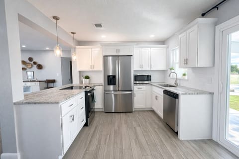 Beautifully remodeled kitchen with stainless steel appliances. Sliders to patio