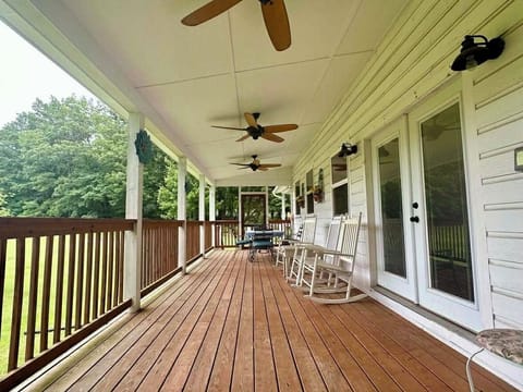 Expansive back porch with rocking chairs & fans; sits on five rolling acres