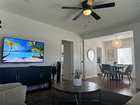 Bright and modern living space with a cozy vibe, smart TV, and open dining area.