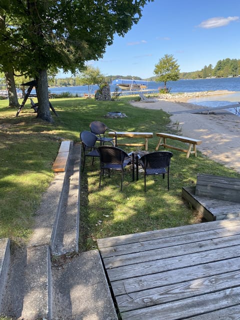 Firepit by lake with firewood provided