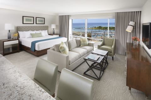 Picture yourself unwinding in this spacious suite with stunning ocean views stretching across the horizon. The plush king bed, cozy seating area, and private balcony invite you to relax in coastal comfort after a day by the water.