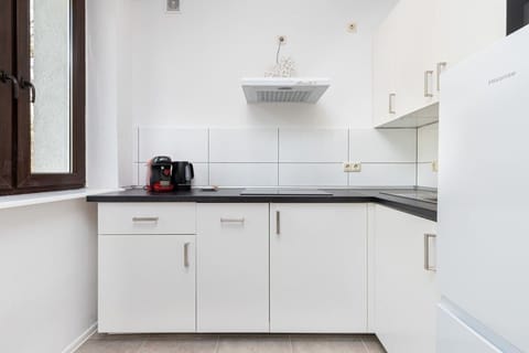 Functional kitchenette space with hob, fridge and dishwasher.
