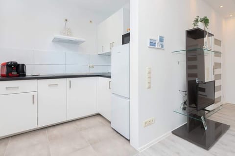 Kitchen with white furniture and matching white tiles, Vlat jets black.