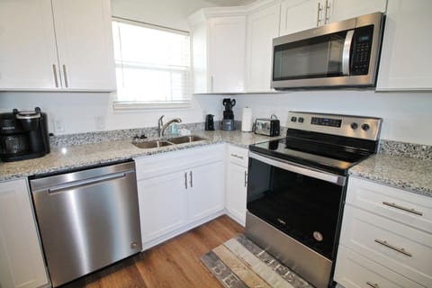 The kitchen features stainless appliances and a drip and kerug coffee maker.