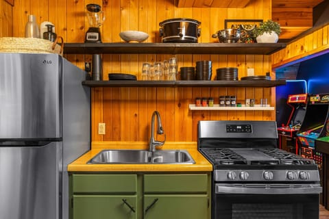 Cook up your favorites in a thoughtfully equipped kitchen featuring open shelving, modern appliances, plenty of dishes, cookware, and a spice rack to kick things up.