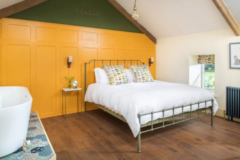 Panelled bedroom with Super King size bed and free-standing bath