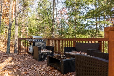 Spacious deck w/ outdoor seating, surrounded by tall trees & peaceful wooded views