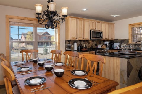 Your fully equipped kitchen and dining space invites memorable meals with loved ones around the warm wooden table.