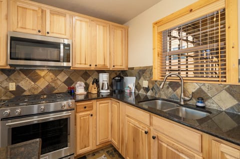 Cook your favorite meals in this fully equipped kitchen with granite counters, stainless appliances, and warm wood cabinets.