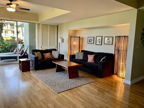 Big comfy couch and love seat in bright, open living room. Wooden doors can cover the windows to make this an extra sleeping space-large futon cushion included.