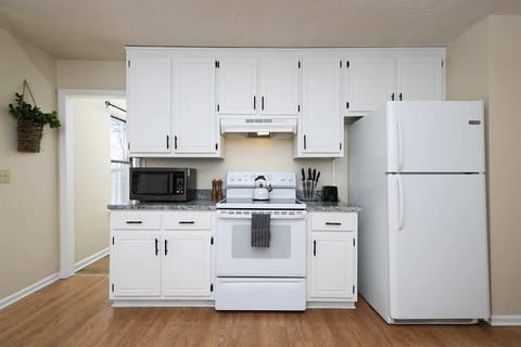 A fully stocked kitchen equipped with appliances, utensils and kitchen wares.