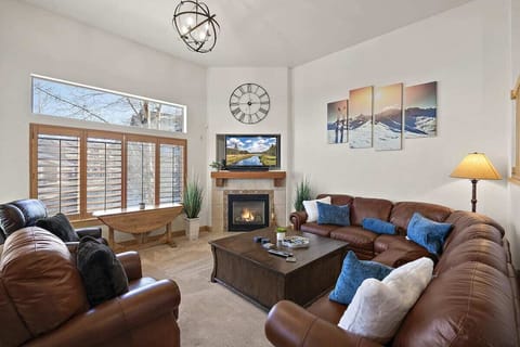 Living area with window views, high ceilings, gas fireplace and 57" TV
