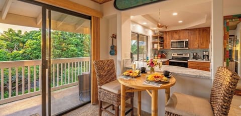 Full kitchen, dining area, and private lanai surrounded by tropical greenery