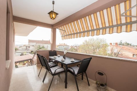 The terrace at the entrance equipped with a garden table and chairs, awning