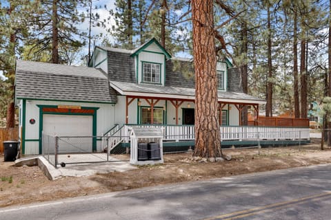 Welcoming cabin entry surrounded by towering pine trees, offering fresh mountain air and a peaceful forest setting—the perfect first impression for your Big Bear Lake getaway.