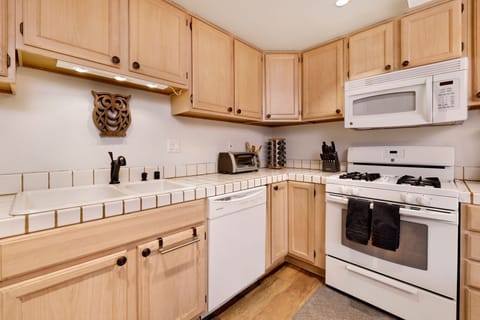 Fully equipped cabin kitchen with ample cabinetry, stove, fridge, microwave, and coffee maker—perfect for cooking meals, morning coffee, and feeling right at home on your stay.