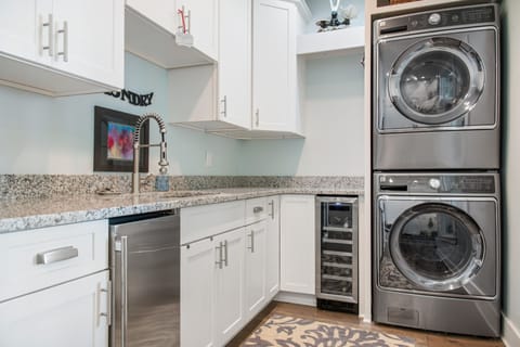 Laundry room with ice maker and wine fridge