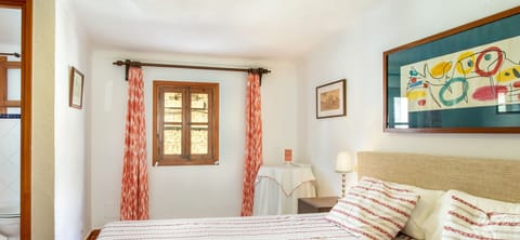 Main bedroom in a Mallorcan village house with a double bed, natural light and traditional décor.