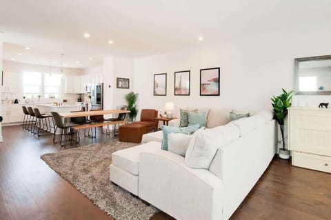 Relax and gather in a bright, open layout connecting the living room, dining table, and kitchen.