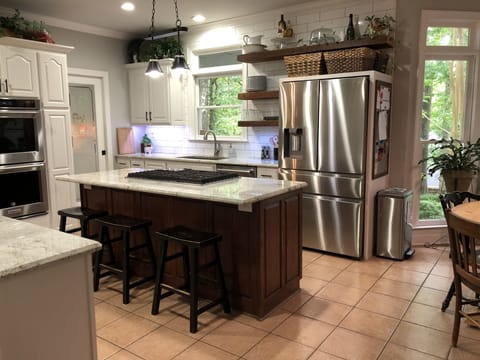 Kitchen with gas range, double oven, coffee bar, and large country sink.
