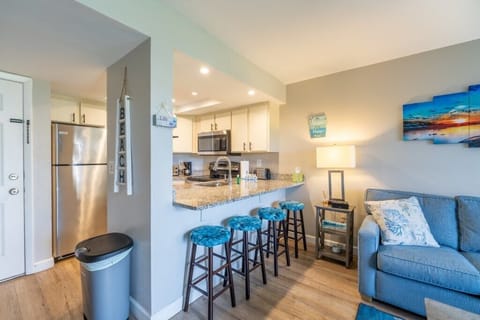 Bright kitchen with bar seating and modern appliances, steps from the beach.