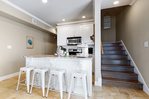 Kitchen and bar area with 4 barstools.