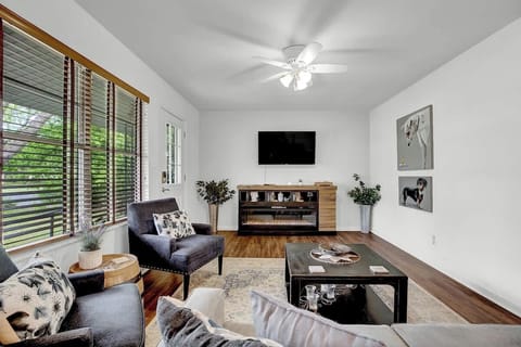 In this snug living room adorned with whimsical art, a flatscreen TV beckons from across the room, surrounded by plush, inviting furnishings that promise a haven of comfort and entertainment.