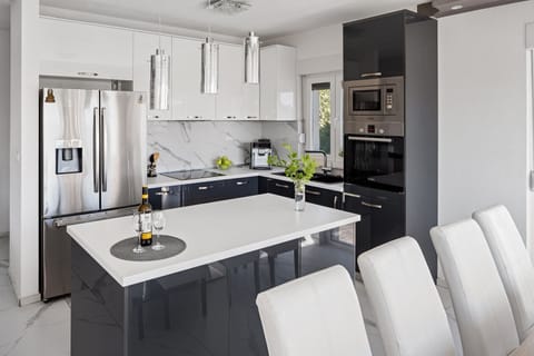 The modern kitchen contains such cooler, microwave, coffee maker, toaster, and kettle.