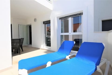 Another view of the sunny balcony with two loungers and extra outdoor dining area