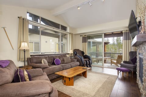 Sink into plush sofas by the fireplace, where your mountain getaway unfolds through expansive windows.