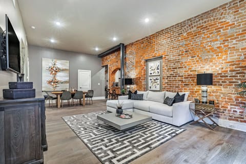 Open-concept living and dining area with plenty of seating. Relax on the large sectional and enjoy the Samsung Smart 4K TV with streaming and DIRECTV Entertainment. Dining table seats six—perfect for gatherings after a fun-filled day in NOLA!