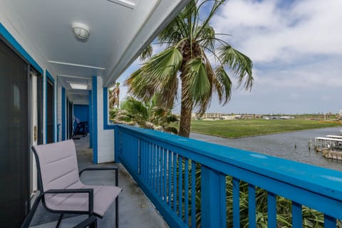 Step onto your private balcony where comfortable seating awaits, overlooking swaying palm trees and peaceful waterfront views that stretch to the horizon.