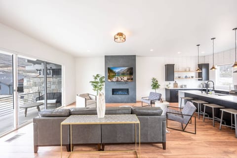 The welcoming open concept floor plan is filled with a refined combination of matte black, chic white and warm woods to create a chic interior
