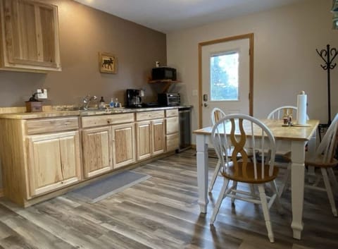 Kitchenette and dining table, Dishes to serve 4. Small appliances include: mini refrigerator, coffee maker, microwave, toaster oven. 