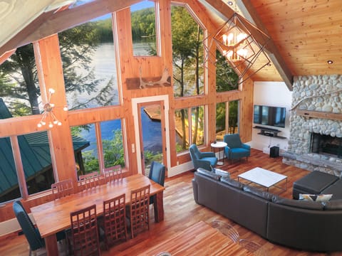 The Great Room w/ soaring cathedral ceilings, a grand chandelier and lake views